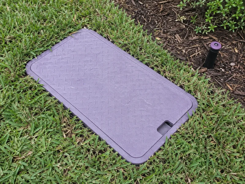 Purple valve-box lid marking a reclaimed water irrigation system